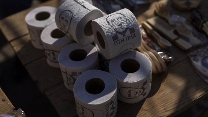 Wajah Putin Hiasi Tisu Toilet hingga Sasaran Latihan Tembak EDS NOTE: OBSCENE LANGUAGE - Toilet roll papers with pictures of Russian President Vladimir Putin and slur messages are for sale in a flea market in Lviv, western Ukraine, on Sunday, March 20, 2022. The text reads