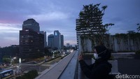 Seorang pengujung mengabadikan suasana sore di kawasan Thamrin.