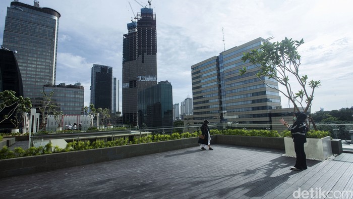 Pengunjung berfoto di area Mall Sarinah, Jakarta, Senin (21/3/2022). Usai dipercantik kini mall tersebut juga memiliki spot untuk melihat senja di Ibu Kota lho..