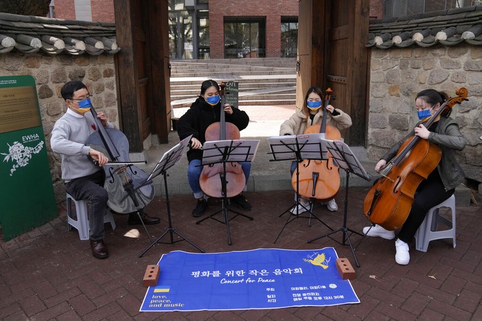 Bermain Cello, Berharap Ukraina-Rusia Segera Damai A professor and students from Ewha Womans University wearing masks in the colors of Ukraine's flag hold an outdoor mini-concert for peace in Seoul, South Korea, Monday, March 21, 2022. (AP Photo/Lee Jin-man)