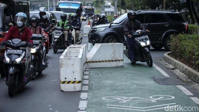 Sejumlah pengendara melintas di jalan Sudirman, Jakarta, Selasa (22/3/2022). Nampak pembatas jalur sepeda bernama Sabuk Nusantara ini hampir menutupi jalur sepeda.