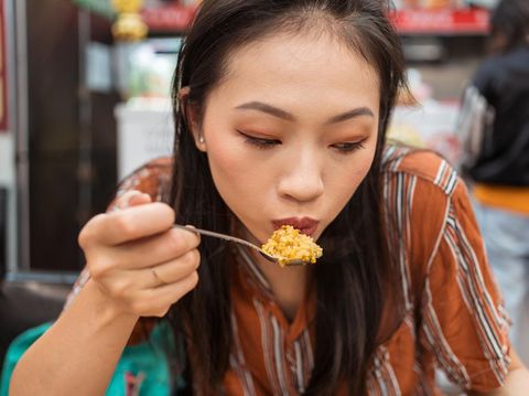 Portrait of beautiful Asian woman eating fried rice in restaurant in Taiwan