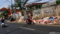 Sampah dibuang oleh warga yang melintas.
