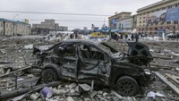 Sebuah mobil rusak berada di alun-alun setelah penembakan gedung Balai Kota di Kharkiv, Ukraina, Selasa, (1/3/2022). (AP Photo/Pavel Dorogoy)