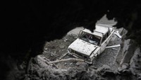 Sebuah mobil yang rusak terlihat dari lubang gedung apartemen yang rusak menyusul serangan roket di kota Mariupol, Ukraina, Jumat, (25/2/2022). (AP/Evgeniy Maloletka)