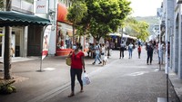 Orang-orang berjalan-jalan di pusat kota Saint Denis, di pulau La Reunion.
