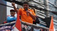 Said Iqbal mengenakan baju Partai Buruh saat berorasi di tengah massa aksi. Ia merupakan presiden atau ketua umum partai tersebut.