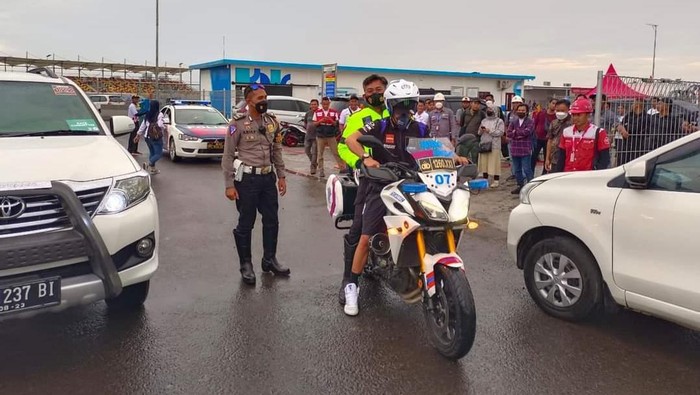Morbidelli mengendarai motor patwal sambil membonceng seorang polisi.