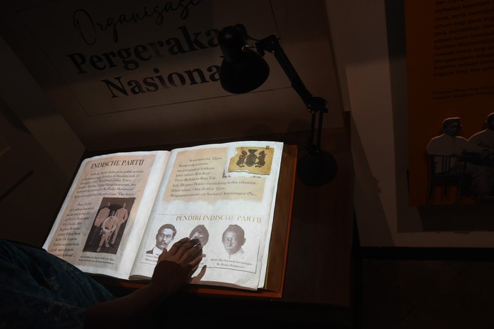 Petugas museum menunjukkan buku sejarah terbentuknya Sumpah Pemuda yang telah diarsipkan ke dalam format digital di Museum Sumpah Pemuda, Kramat, Jakarta, Selasa (22/3/2022). Museum Sumpah Pemuda kembali dibuka pascarevitalisasi dengan menampilkan sejumlah perubahan dalam format penyajian informasi menjadi lebih interaktif ke dalam bentuk teknologi digital guna menarik perhatian pengunjung khususnya kaum milenial. ANTARA FOTO/Indrianto Eko Suwarso/tom.