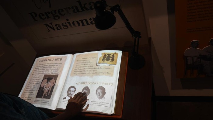 Petugas museum menunjukkan buku sejarah terbentuknya Sumpah Pemuda yang telah diarsipkan ke dalam format digital di Museum Sumpah Pemuda, Kramat, Jakarta, Selasa (22/3/2022). Museum Sumpah Pemuda kembali dibuka pascarevitalisasi dengan menampilkan sejumlah perubahan dalam format penyajian informasi menjadi lebih interaktif ke dalam bentuk teknologi digital guna menarik perhatian pengunjung khususnya kaum milenial. ANTARA FOTO/Indrianto Eko Suwarso/tom.