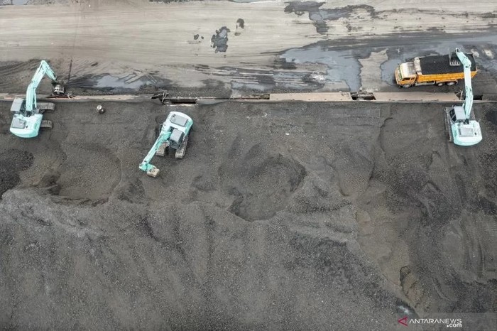 Pekerja mengoperasikan alat berat saat bongkar-muat batu bara ke dalam truk di Pelabuhan PT Karya Citra Nusantara (KCN), Marunda, Jakarta, Rabu (12/1/2022). (ANTARA FOTO/M Risyal Hidayat/foc)