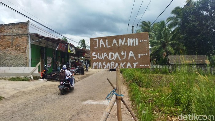Warga Kampung Kadomas, Kelurahan Kadomas, Pandeglang, Banten, swadaya memperbaiki jalan rusak karena belasan tahun tak diurus pemerintah. (Aris Rivaldo/detikcom)