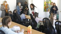 Anak-anak dengan gugup menggenggam erat buku ajar, pensil, dan penghapus saat para guru menyambut mereka di kelas. Mereka akan mengikuti kurikulum Ukraina dan juga belajar bahasa Jerman.  