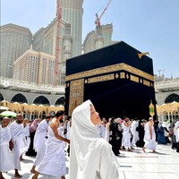 Saat umrah, Fuji mengenakan abaya polos dan hijab syari warna putih. Fuji memakai inner hijab warna hitam agar bagian depan rambutnya tak terlihat. Ia berpose tepat di depan Kabah. Foto: Dok. Instagram @fuji_an.