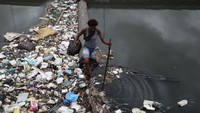 Claudia Stella Alves dos Reis (24) berjalan di atas Sungai Arroio Fundo yang penuh sampah.  
