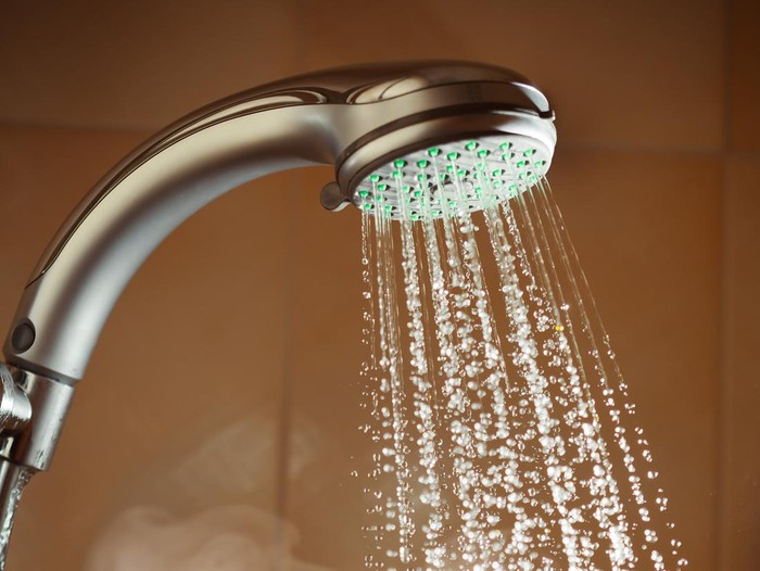 Ilustrasi mandi shower with flowing water and steam, closeup view