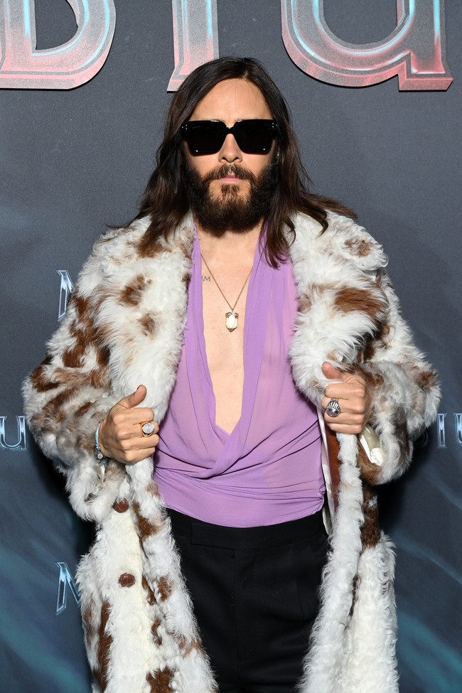 Untuk bawahan, celana panjang hitam menjadi andalan. Di deretan aksesori, ada kacamata hitam oversized. Tidak ketinggalan, sepasang boots putih berhak menyempurnakan gaya retronya yang nyentrik. (Foto: Getty Images/Pascal Le Segretain)