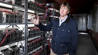 CEO Stronghold Digital Mining, Greg Beard, menunjukkan salah satu komponen mesin komputer pembuat bitcoin.