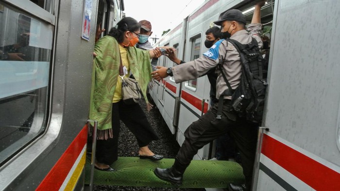 Momen Penumpang Pindah KRL Gegara Gangguan Listrik Petugas membantu penumpang KRL Commuterline berpindah rangkaian kereta di kawasan Cipinang, Jakarta Timur, Rabu (23/3/2022). Pemindahan penumpang untuk melanjutkan perjalanan menuju Jakarta Kota tersebut akibat gangguan Listrik Aliran Atas (LAA) antara stasiun Jatinegara-Cakung. ANTARA FOTO/Paramayuda/YU