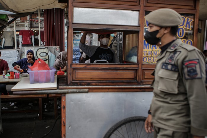 Petugas Satpol PP meminta pedagang untuk menutup lapak dagangnya di kawasan kuliner Pasar Lama, Kota Tangerang, Banten, Rabu (2/2/2022). Pemerintah setempat menutup kawasan kuliner Pasar Lama karena dinilai kerap menimbulkan kerumunan yang bisa menjadi lokasi penularan COVID-19. ANTARA FOTO/Fauzan/aww.