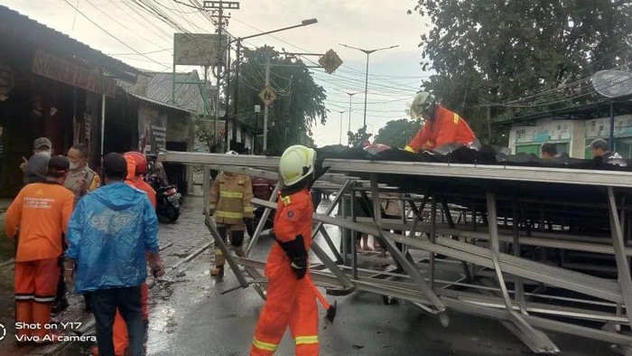 Sebuah kanopi yang terbuat dari baja ringan di Jaktim roboh akibat angin kencang. Atap baja tersebut telah dievakuasi sehingga tak lagi menutup jalanan. (Instagram @damkarjakartatimur)