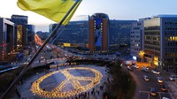 Lilin dan lampu membentuk tanda perdamaian raksasa selama aksi penjagaan perdamaian di depan gedung Dewan dan Komisi Eropa pada Selasa, (22/3/2022), di Brussel, Belgia. (AP/Olivier Matthys)