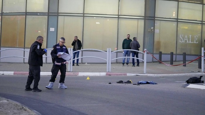 Aksi Teroris Tabrak-Tikam Warga di Israel Hingga Tewas Members of Israeli ZAKA emergency and response team clean the blood stains at the scene of an attack in Beersheba, southern Israel, Tuesday, March 22, 2022. A knife-wielding Arab man killed several people and seriously wounded others in the southern Israeli city of Beersheba, a rampage officials called a terror attack with nationalist motives. (AP Photo/Tsafrir Abayov)