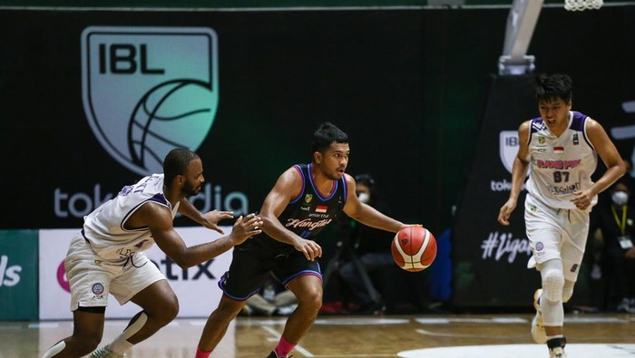 Pebasket Amartha Hangtuah Jakarta Stevan Wilfredo Neno (tengah) berusaha melewati pebasket Rans PIK Basketball Club Akeem W Scoot (kiri) dan Agus Salim (kanan) pada pertandingan lanjutan Indonesian Basketball League (IBL) 2022 di Hall Basket Kompleks Gelora Bung Karno (GBK), Senayan, Jakarta, Senin (14/3/2022). Rans PIK Basketball Club mengalahkan Amartha Hangtuah Jakarta dengan skor 66-64. ANTARA FOTO/Rivan Awal Lingga/rwa.