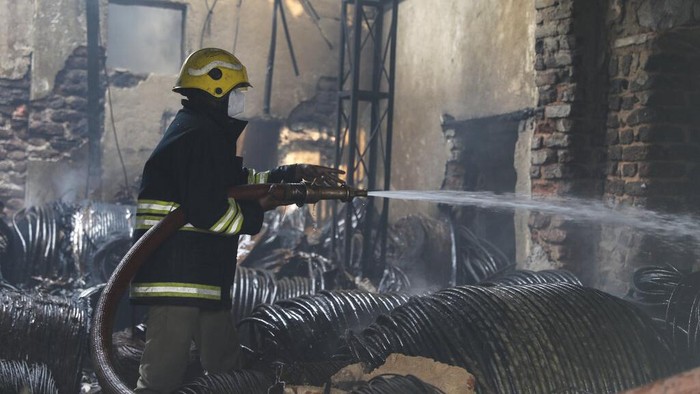 Gudang Barang Bekas di India Kebakaran, Belasan Orang Tewas A young neighbor looks on as fire men try to douse a fire that broke out at a scrap warehouse in Hyderabad, India, Wednesday, March 23, 2022. The fire killed at least 11 people and injured four others. AP Photo/Mahesh Kumar A)