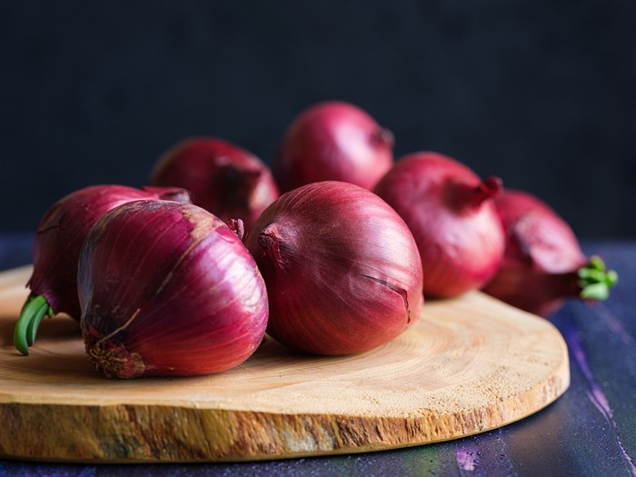 Red onions on wood board