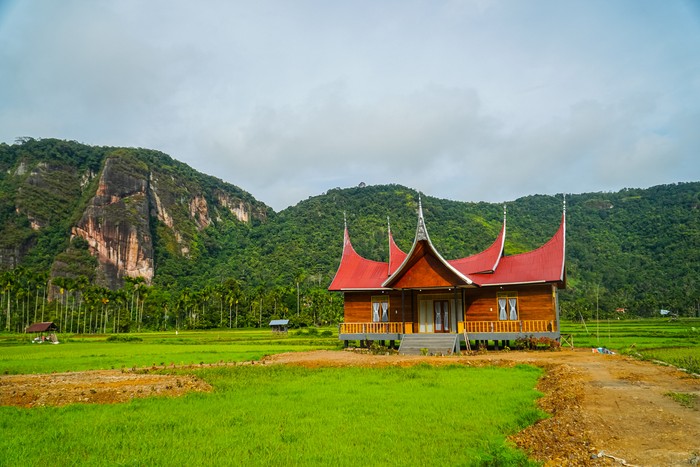 Minangkabau house or Rumah Gadang in a beautiful landscape view of Harau Valley with mountains valley and grass view, West Sumatra, Indonesia. Beautiful Minangkabau, Indonesia Landscape.