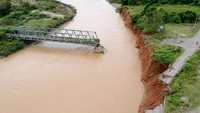 Foto udara kondisi jalan dan jembatan yang amblas di Suwawa Selatan, Kabupaten Bone Bolango, Gorontalo, Rabu (23/3/2022).