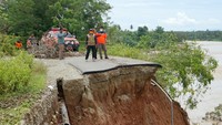 Petugas BPBD dan BNPB meninjau kondisi jalan dan jembatan yang amblas di Suwawa Selatan, Kabupaten Bone Bolango, Gorontalo.