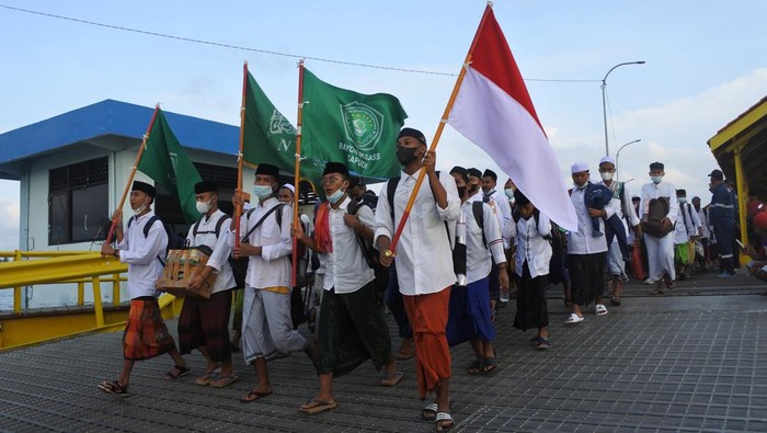 Sejumlah santri calon penumpang antre memasuki KMP Satya Kencana di area Pelabuhan Jangkar, Situbondo, Jawa Timur, Rabu (23/3/2022). Sejumlah santri yang belajar di pondok pesantren Sukorejo, Situbondo mulai pulang kampung ke Pulau Sapudi, Sumenep menyusul datangnya Bulan Ramadhan, masa libur belajar dan harus sudah menjalani vaksin dosis kedua untuk lolos naik KMP. ANTARA FOTO/Seno/foc.