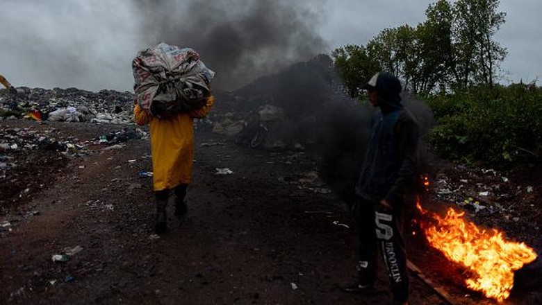 Mencari Nafkah di Tempat Pembuangan Sampah Terbesar Argentina LUJAN, ARGENTINA - MARCH 23: Men work as garbage falls from a garbage truck to sort and sell its residues on March 23, 2022 in Lujan, Argentina. Despite the official announcements of a plan to reconvert the biggest garbage dump of Argentina into a recycling and waste treatment center, the surrounding areas of Lujan, in the outskirts of the city of Buenos Aires, continue to be hit pollution. While some residents are sceptical on the viability of the project, funded by the Inter-American Development Bank, others worry about a potential loss of their source of income. An estimate of 150 families struggle to make a living collecting rubbish from this open-air dump of over 12 hectares where 120 tons of waste are thrown, feeding mountains of rubbish up to 30 meters. (Photo by Tomas Cuesta/Getty Images)