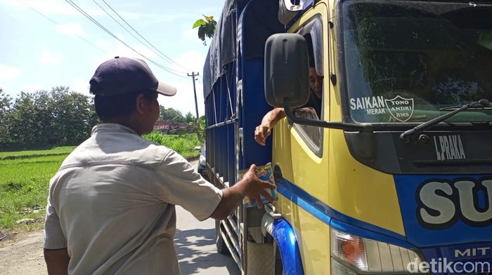 Warga meminta sumbangan kepada pengguna jalur alternatif Rembang-Pati, Kamis (24/3/2022).