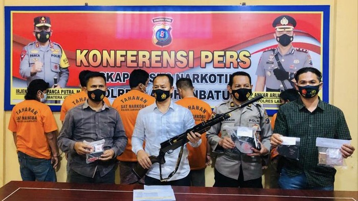 Polisi Labuhanbatu Utara dengan barang bukti narkoba dan senapan angin.