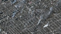 Kondisi di distrik Livoberezhnyi, Mariupol, pada 22 Maret 2022. Tampak sejumlah bangunan mengeluarkan asap.