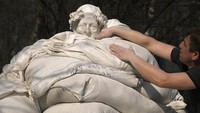 Warga menutupi patung penyair dan pemikir Italia Dante Alighieri dengan karung pasir di kawasan Kyiv, ibu kota Ukraina, Rabu (23/3/2022) waktu setempat.