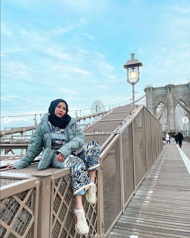 Ayu mengunggah foto OOTD berhijab di Brooklyn Bridge, New York. Ia memakai setelan outfit Dior dan jaket tebal. Ayu memakai hijab segi empat hitam dipadu dengan sneakers putih. Foto OOTD Ayu kembali mendapatkan pujian dari warganet. Foto: Dok. Instagram @ayuaulia5252