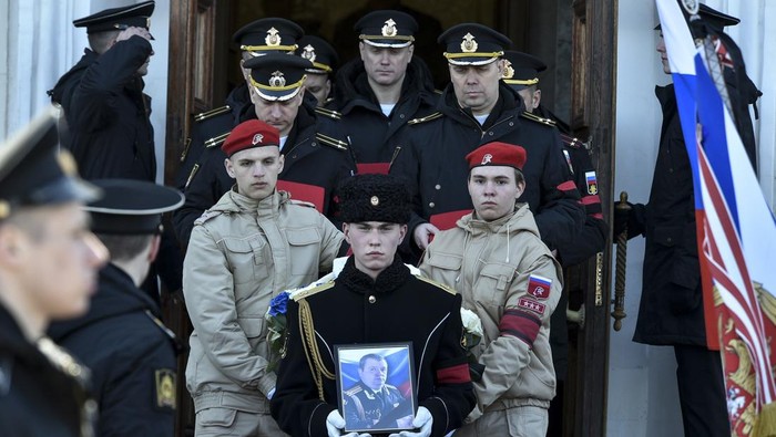 A serviceman carries the photo of Capt. Andrei Paliy, a deputy commander of Russia's Black Sea Fleet, during a farewell ceremony in Sevastopol, Crimea, Wednesday, March 23, 2022. Paliy was killed in action during the fighting with Ukrainian forces in the Sea of Azov port of Mariupol. (AP Photo)