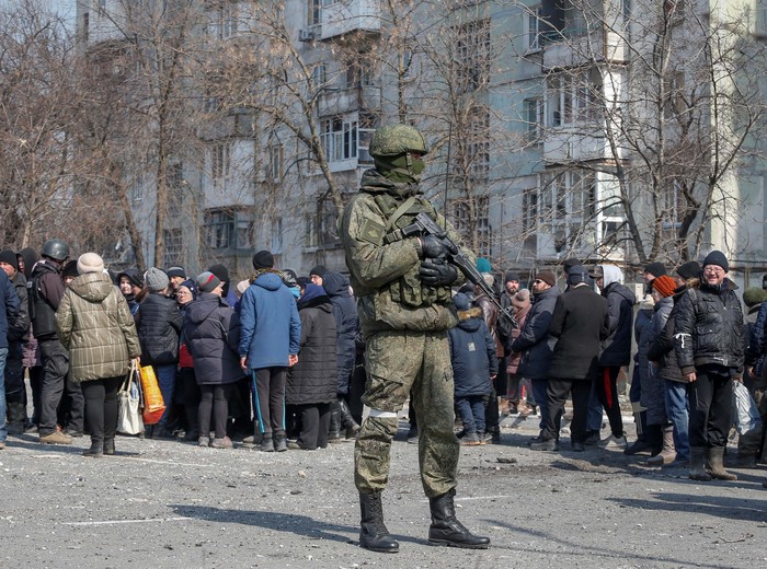 Warga Mariupol Antre Panjang untuk Terima Bantuan Makanan Local residents carry humanitarian aid delivered by Russian soldiers during Ukraine-Russia conflict, in the besieged southern port of Mariupol, Ukraine March 23, 2022. REUTERS/Alexander Ermochenko