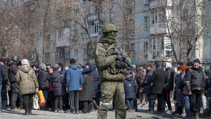 Local residents carry humanitarian aid delivered by Russian soldiers during Ukraine-Russia conflict, in the besieged southern port of Mariupol, Ukraine March 23, 2022.  REUTERS/Alexander Ermochenko