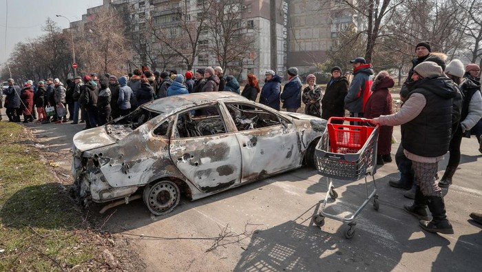 Local residents carry humanitarian aid delivered by Russian soldiers during Ukraine-Russia conflict, in the besieged southern port of Mariupol, Ukraine March 23, 2022.  REUTERS/Alexander Ermochenko