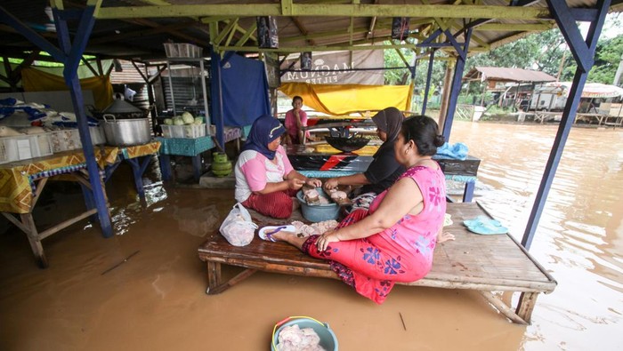 Warga beraktivitas di rumahnya yang terendam banjir di Desa Kedawung, Grati, Pasuruan, Jawa Timur, Jumat (25/3/2022). Menurut data Badan Penanggulangan Bencana Daerah (BPBD) Kabupaten Pasuruan, sebanyak 268 Kepala Keluarga (KK) terdampak banjir dengan ketinggian hingga 80 cm akibat hujan deras dan luapan Sungai Rejoso. ANTARA FOTO/Umarul Faruq/aww.