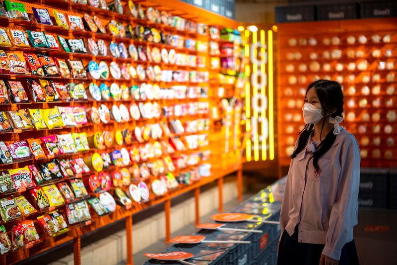 A student browses instant noodles at the Good Noodle store in Bangkok, Thailand, March 21, 2022. Picture taken March 21, 2022. REUTERS/Athit Perawongmetha