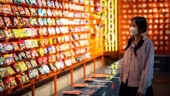 Ada 'Surga' Pecinta Mi Instan di Thailand A student browses instant noodles at the Good Noodle store in Bangkok, Thailand, March 21, 2022. Picture taken March 21, 2022. REUTERS/Athit Perawongmetha