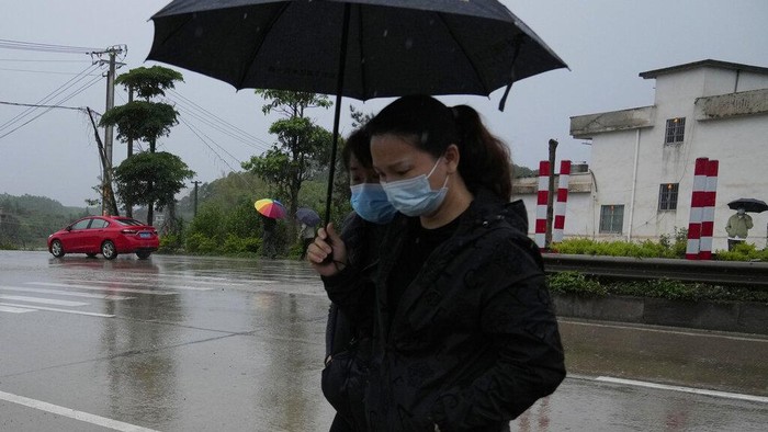 Duka Keluarga Korban di Lokasi Pesawat Jatuh A relative of passengers onboard the China Eastern Flight 5735 cries as she is escorted near the crash site, Thursday, March 24, 2022, in Shentian village, southwestern China's Guangxi province. The search area was expanded Thursday in a