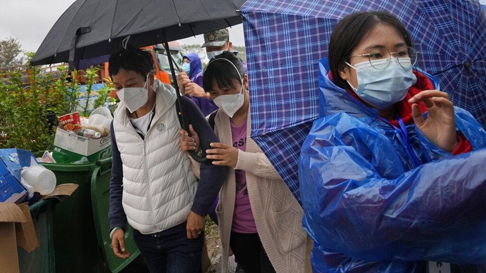 A relative of passengers onboard the China Eastern Flight 5735 cries as she is escorted near the crash site, Thursday, March 24, 2022, in Shentian village, southwestern China's Guangxi province. The search area was expanded Thursday in a 