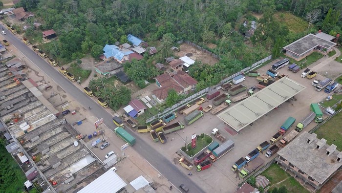 Foto Udara Truk-truk Mengular Antre Solar di Jambi Foto udara sejumlah truk mengantre untuk mengisi bahan bakar solar bersubsidi di SPBU Paal Lima, Kota Baru, Jambi, Jumat (25/3/2022). Antrean kendaraan yang didominasi truk angkutan batu bara itu terjadi di sejumlah SPBU di provinsi itu karena tidak seimbangnya ketersediaan bahan bakar solar bersubsidi dengan kebutuhan kendaraan yang mengantre. ANTARA FOTO/Wahdi Septiawan/aww.